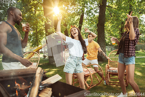 Image of Happy friends are having beer and barbecue party at sunny day