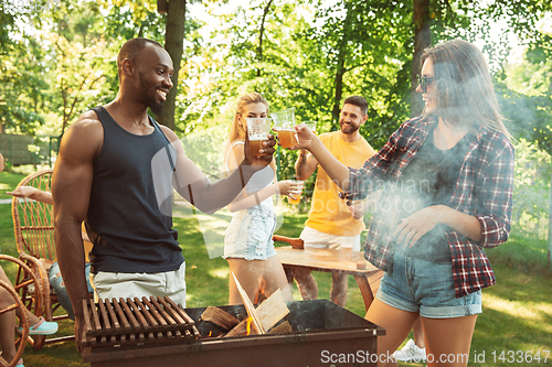 Image of Happy friends are having beer and barbecue party at sunny day