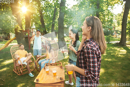 Image of Happy friends are having beer and barbecue party at sunny day