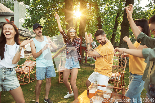 Image of Happy friends are having beer and barbecue party at sunny day