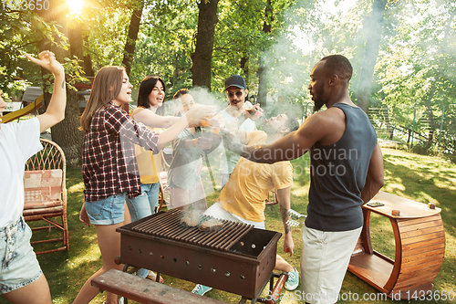 Image of Happy friends are having beer and barbecue party at sunny day