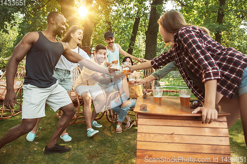 Image of Happy friends are having beer and barbecue party at sunny day