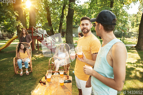 Image of Happy friends are having beer and barbecue party at sunny day