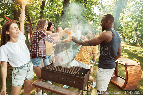 Image of Happy friends are having beer and barbecue party at sunny day