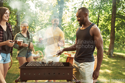 Image of Happy friends are having beer and barbecue party at sunny day