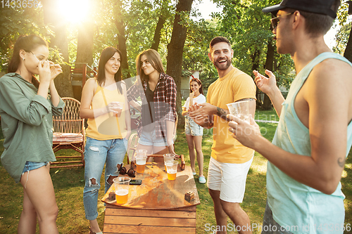 Image of Happy friends are having beer and barbecue party at sunny day