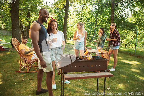 Image of Happy friends are having beer and barbecue party at sunny day