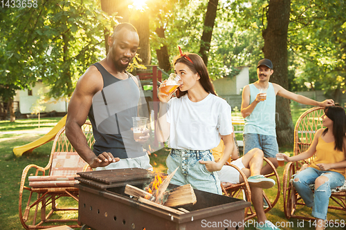 Image of Happy friends are having beer and barbecue party at sunny day