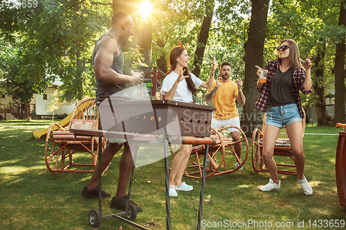 Image of Happy friends are having beer and barbecue party at sunny day