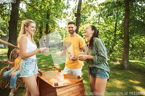 Image of Happy friends are having beer and barbecue party at sunny day