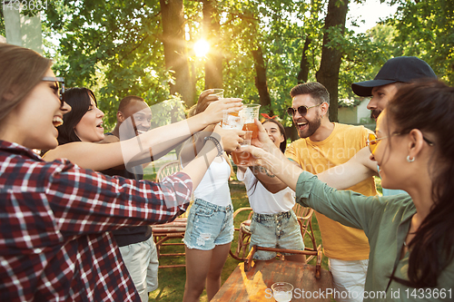 Image of Happy friends are having beer and barbecue party at sunny day