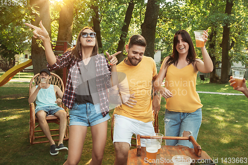 Image of Happy friends are having beer and barbecue party at sunny day