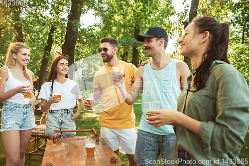 Image of Happy friends are having beer and barbecue party at sunny day