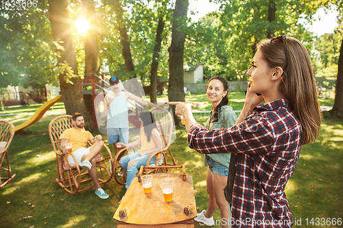 Image of Happy friends are having beer and barbecue party at sunny day