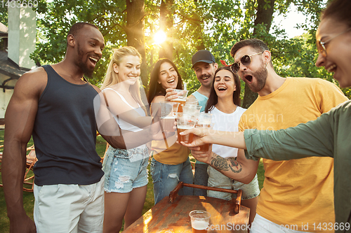 Image of Happy friends are having beer and barbecue party at sunny day