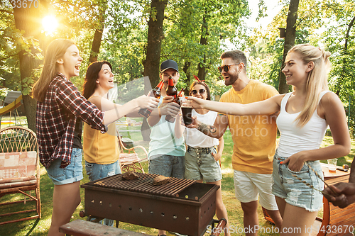 Image of Happy friends are having beer and barbecue party at sunny day