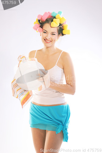 Image of A woman in hair curlers is drying up the plate