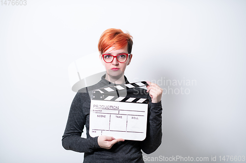 Image of redhead woman holding movie  clapper on white background