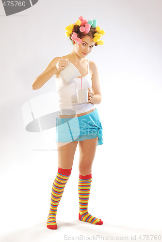 Image of A woman in hair curlers with a teapot and cup