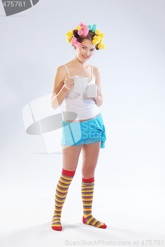 Image of A woman in hair curlers with a teapot and cup