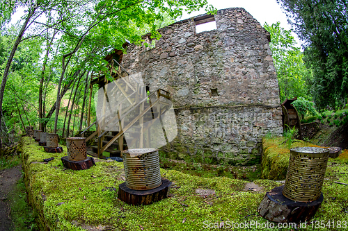 Image of Moss covered ancient mill in old park.