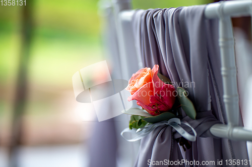 Image of Pink rose tied on the chair 