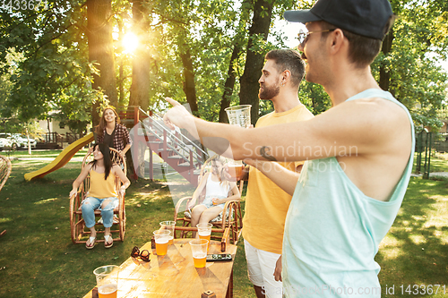 Image of Happy friends are having beer and barbecue party at sunny day