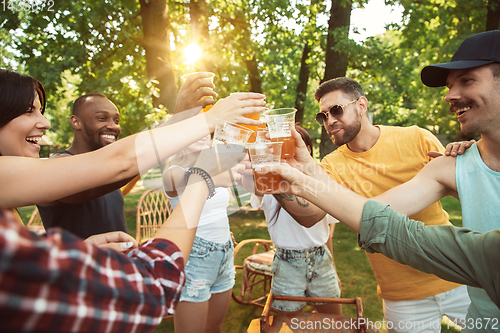 Image of Happy friends are having beer and barbecue party at sunny day