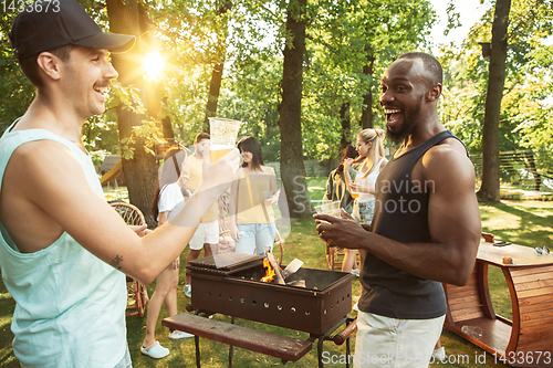 Image of Happy friends are having beer and barbecue party at sunny day