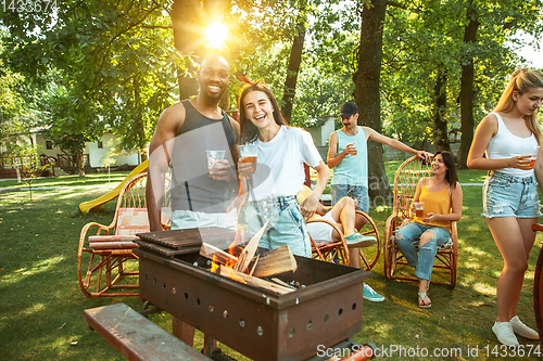 Image of Happy friends are having beer and barbecue party at sunny day