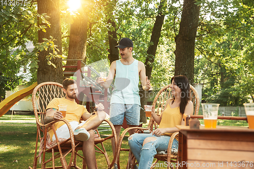 Image of Happy friends are having beer and barbecue party at sunny day