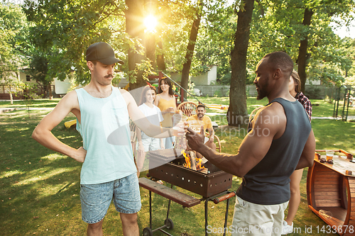 Image of Happy friends are having beer and barbecue party at sunny day