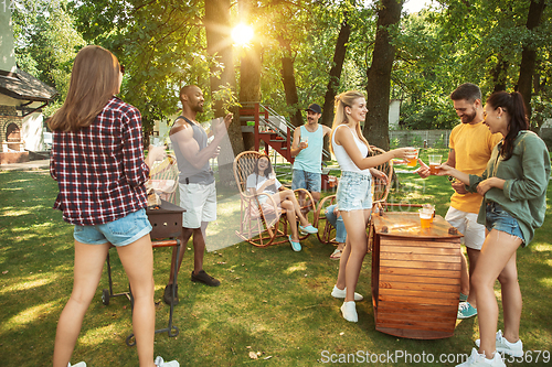 Image of Happy friends are having beer and barbecue party at sunny day