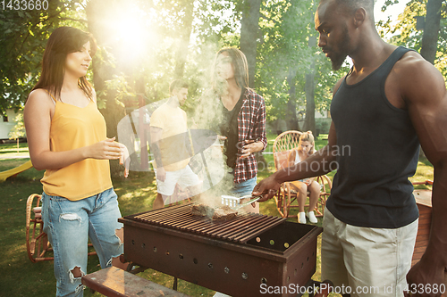 Image of Happy friends are having beer and barbecue party at sunny day