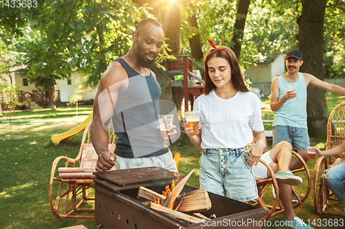 Image of Happy friends are having beer and barbecue party at sunny day