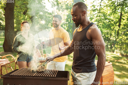 Image of Happy friends are having beer and barbecue party at sunny day