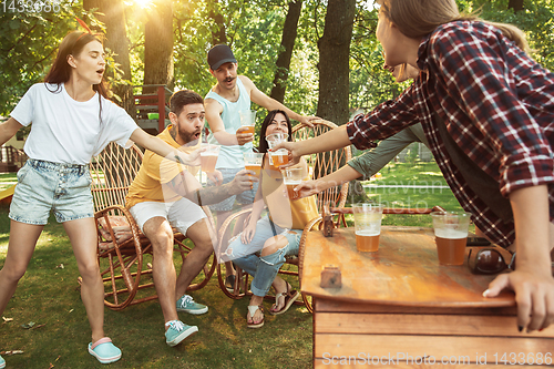 Image of Happy friends are having beer and barbecue party at sunny day