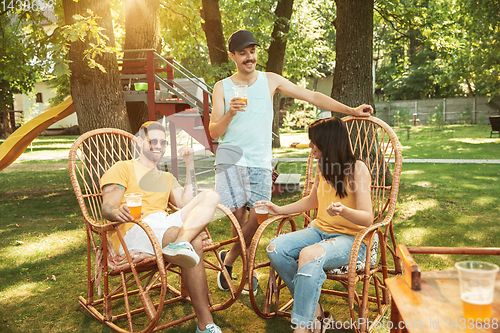 Image of Happy friends are having beer and barbecue party at sunny day