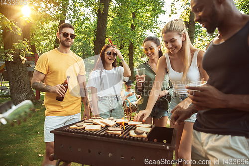 Image of Happy friends are having beer and barbecue party at sunny day