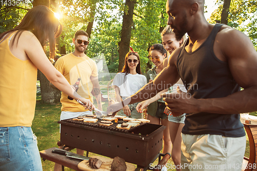 Image of Happy friends are having beer and barbecue party at sunny day