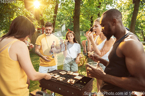 Image of Happy friends are having beer and barbecue party at sunny day