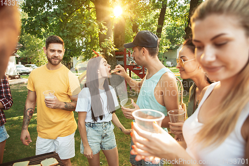 Image of Happy friends are having beer and barbecue party at sunny day