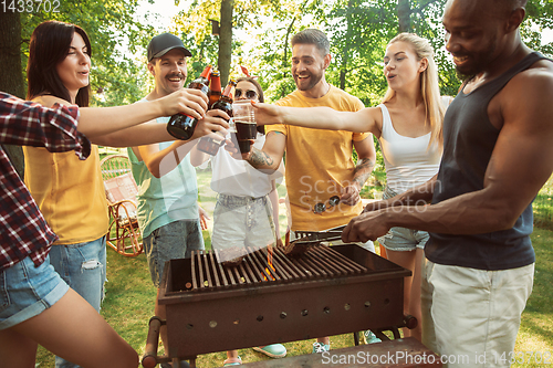 Image of Happy friends are having beer and barbecue party at sunny day