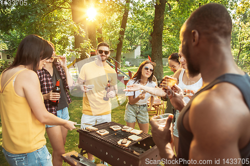 Image of Happy friends are having beer and barbecue party at sunny day