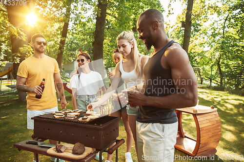 Image of Happy friends are having beer and barbecue party at sunny day