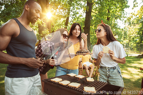 Image of Happy friends are having beer and barbecue party at sunny day