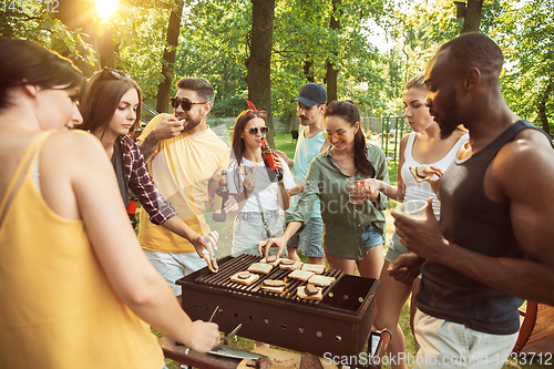 Image of Happy friends are having beer and barbecue party at sunny day