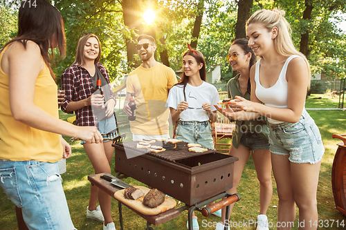 Image of Happy friends are having beer and barbecue party at sunny day