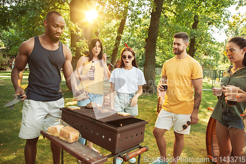 Image of Happy friends are having beer and barbecue party at sunny day