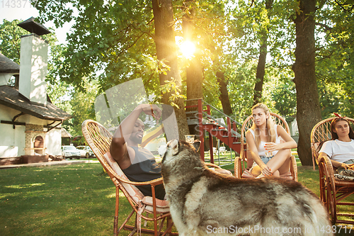 Image of Happy friends are having beer and barbecue party at sunny day